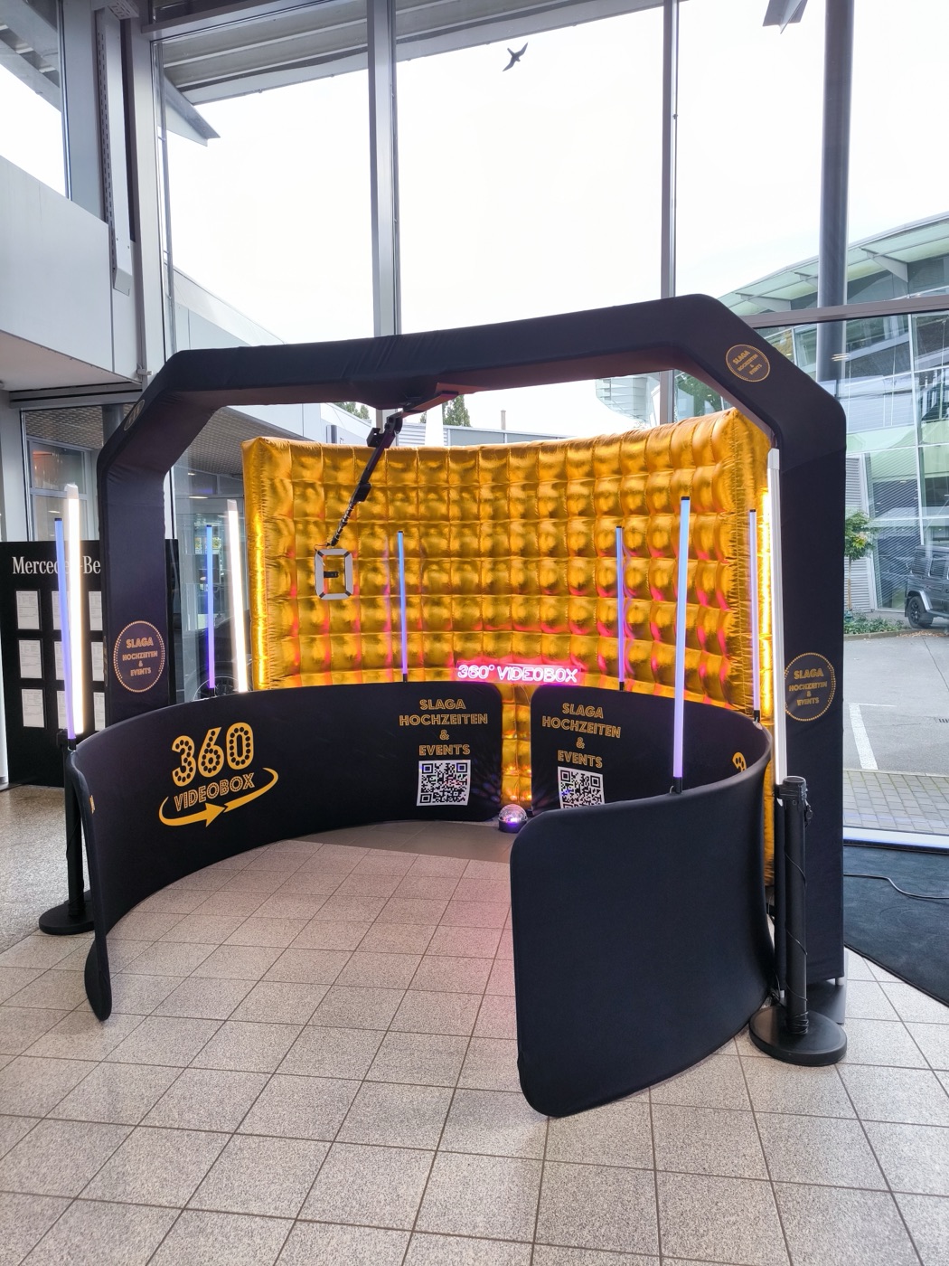 360°-Videobox mit Rundum-Wand und goldenem Hintergrund im Eingangsbereich