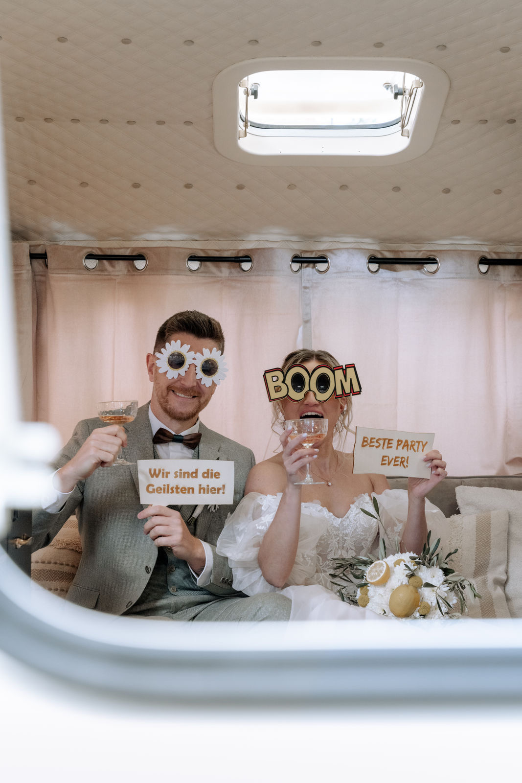 Brautpaar mit Requisiten auf dem Fotosofa im Caravan