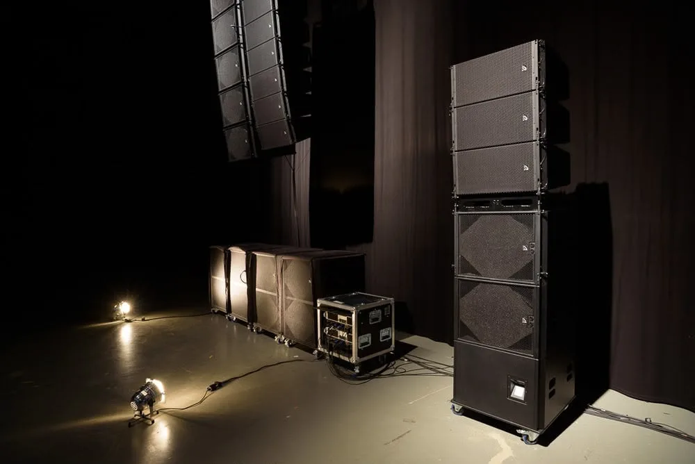 Line-Array-Lautsprecher, Subwoofer und Verstärker-Rack auf einer Bühne
